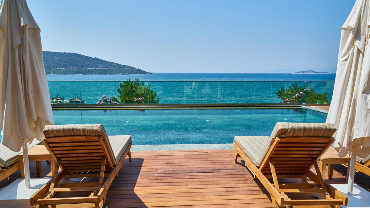 deux transats sur une terrasse avec vue sur la mer et le ciel bleu
